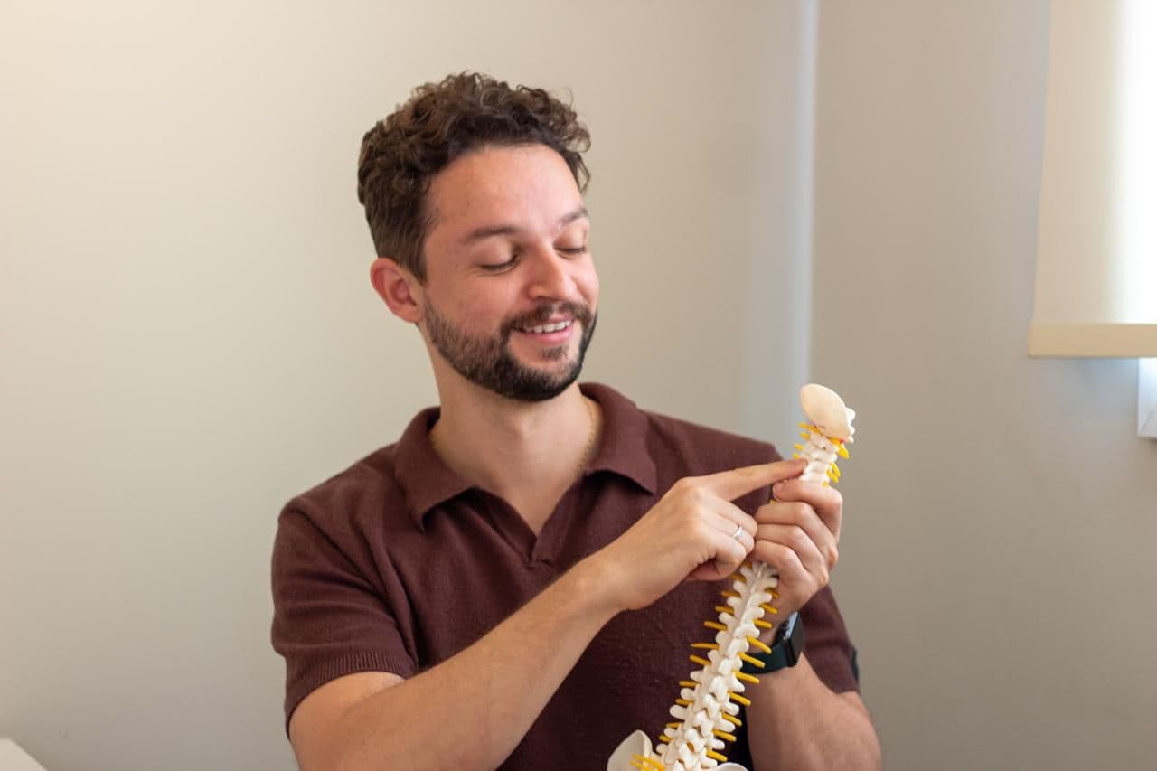 Profissional explicando a anatomia da coluna para o paciente